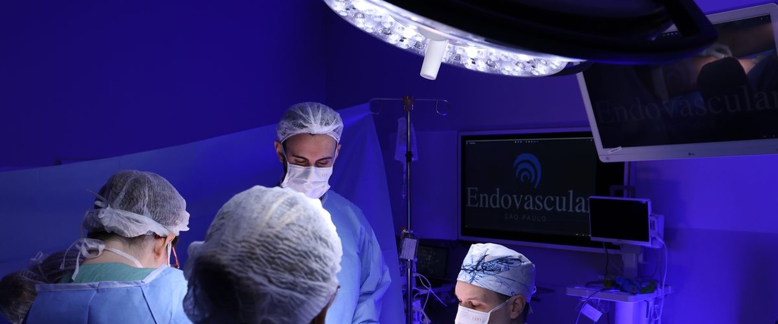 Equipe cirúrgica reunida em centro cirúrgico durante uma cirurgia vascular