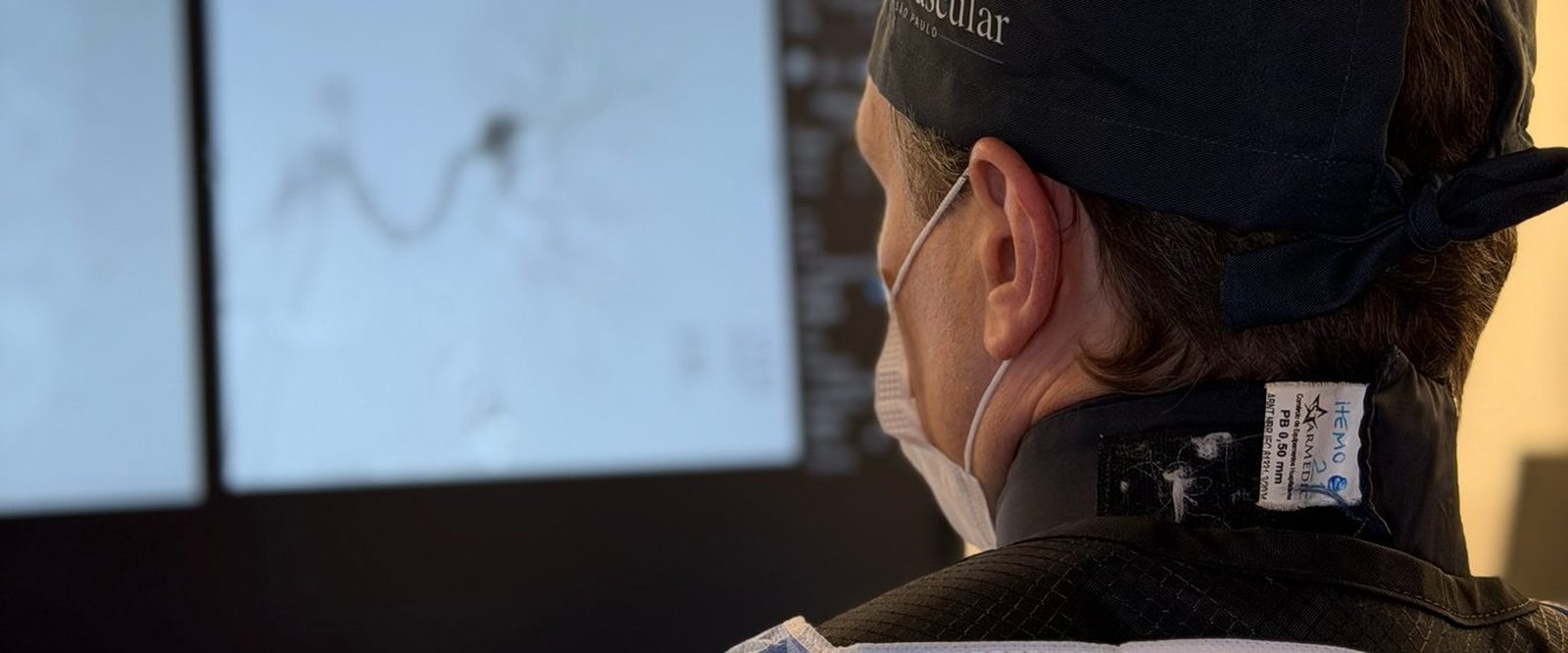 Dr. Igor Sincos de perfil, lendo a angiografia nos monitores da sala