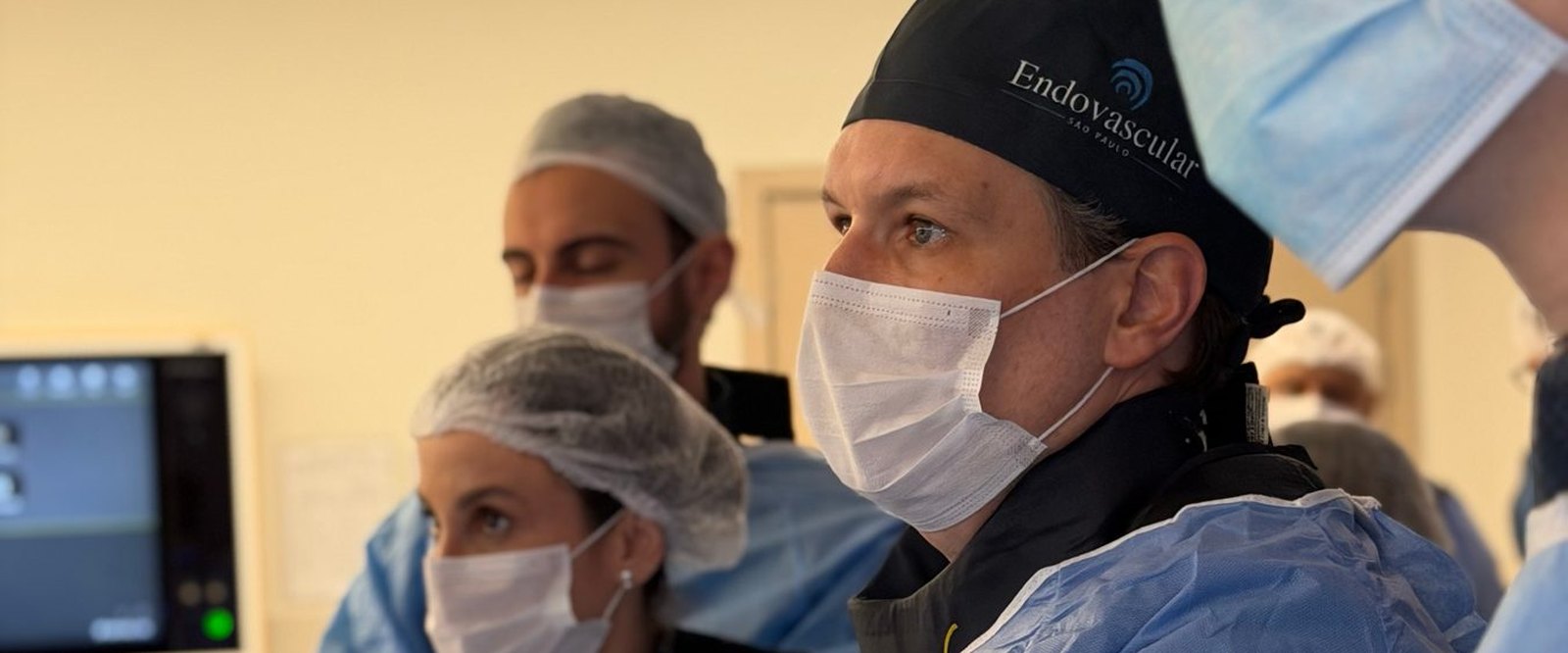 Dr. Igor Sincos conduzindo um procedimento endovascular por punção, com a equipe ao lado